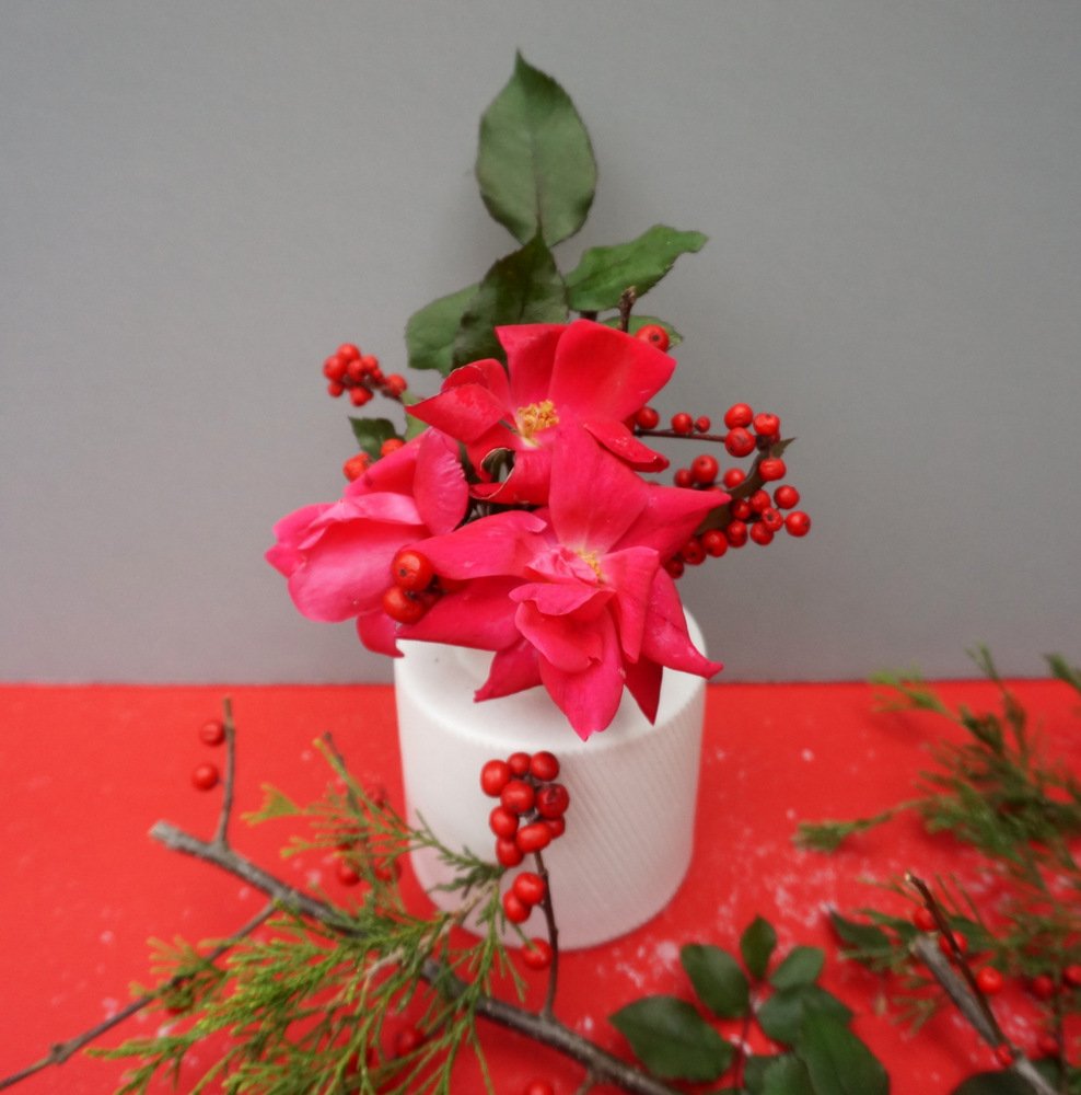 Un centre de table de Noël avec des branches de houx et des fleurs Un centre de table de Noël avec des branches de houx et des fleurs