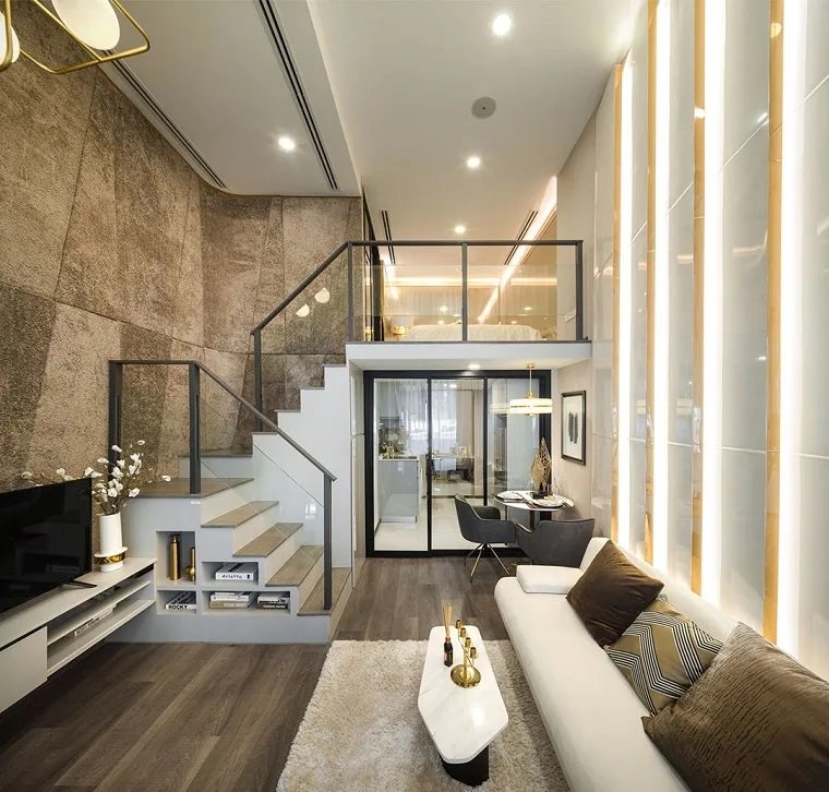 Décor de luxe avec deuxième niveau et escalier avec rampe en verre et métal.