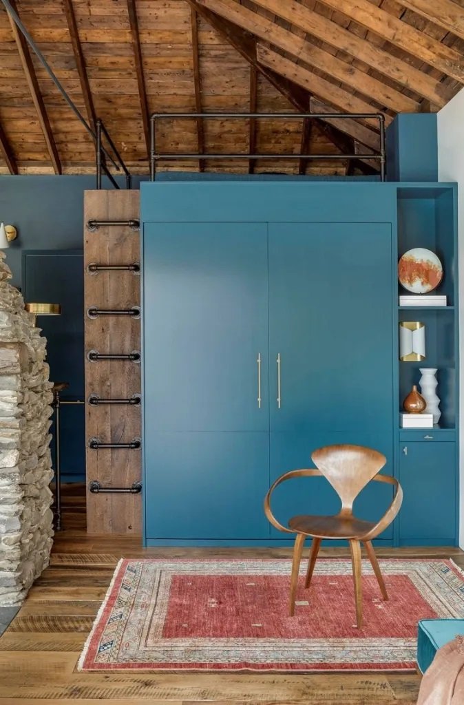 Décoration industrielle avec des touches de bois, du bleu et un tapis rouge