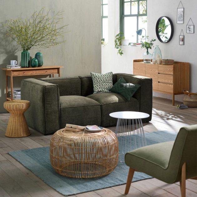 Un canapé en tissu texturé vert kaki foncé et une déco bois
